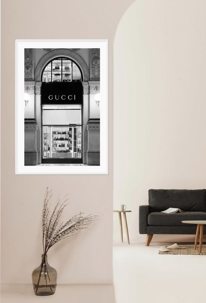 Fashion print with black and white Gucci shopfront faÔøΩade at night with ornamental lights and moulding. 
