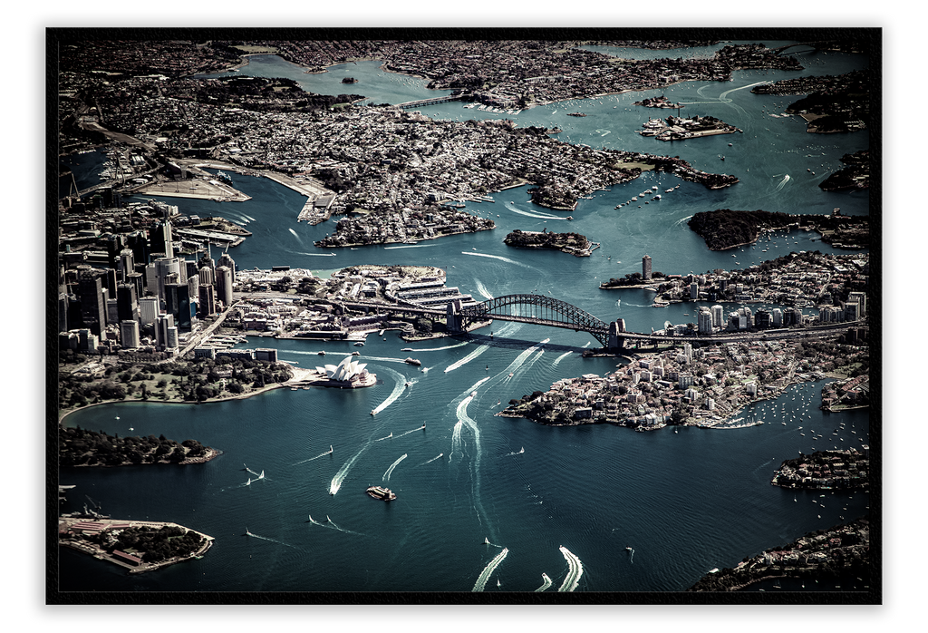 Birds eye view of sydney harbor with dark blue water and grey land  