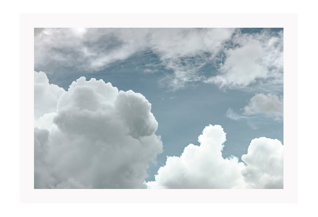 White fluffy cloud sky print with blue background, minimal style 