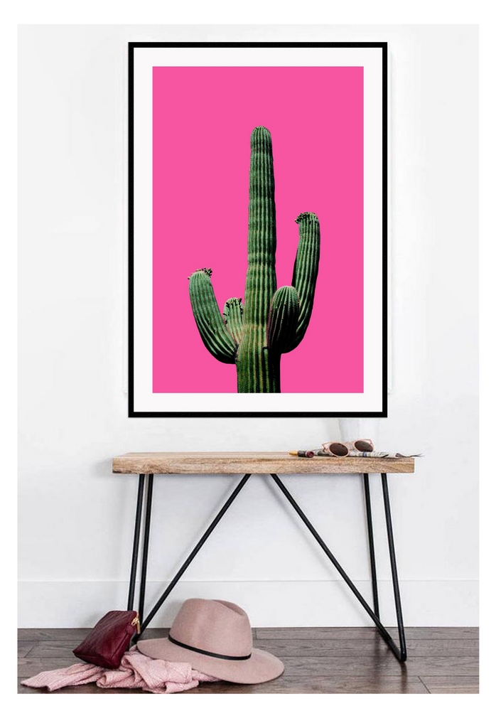 A natural wall art with green cactus on hot pink background. 