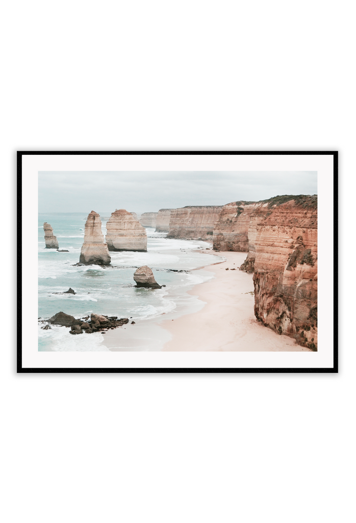 Landscape photography print showing the Twelve Apostles in Victoria, Australia with red rocks and cliffs sorrounded by sand and the ocean.