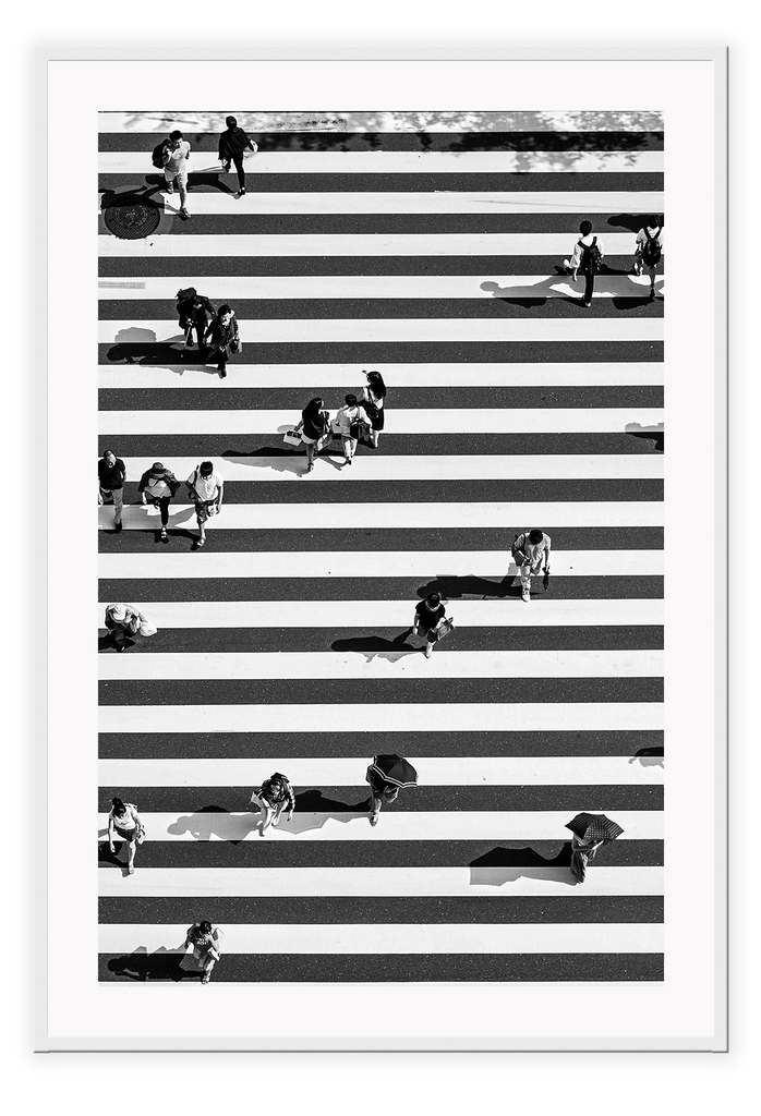 A black and white urban wall art with an aerial view of a busy city street crossing with zebra stripes.