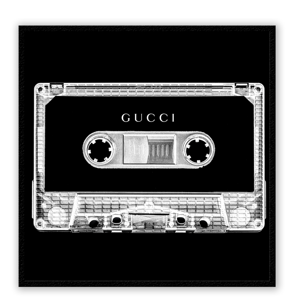 A vintage fashion wall art with Gucci fashion label on 80s 90s vintage cassette tape in fluro black and white inverted colour.