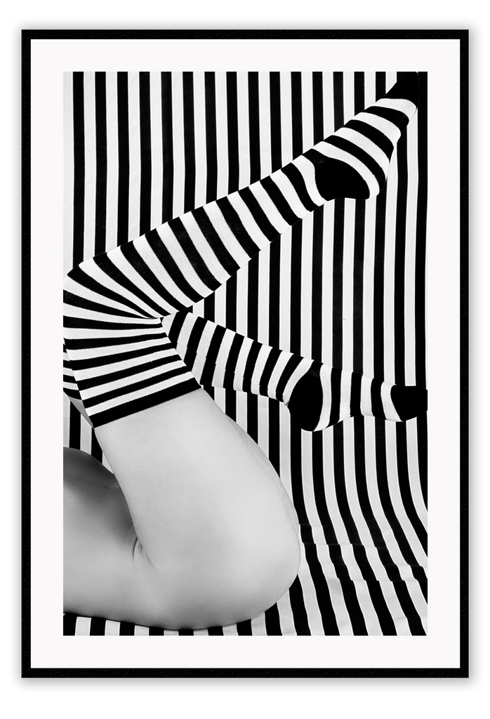 Black and white modern print featuring striped background and bottom half of a woman wearing striped socks.