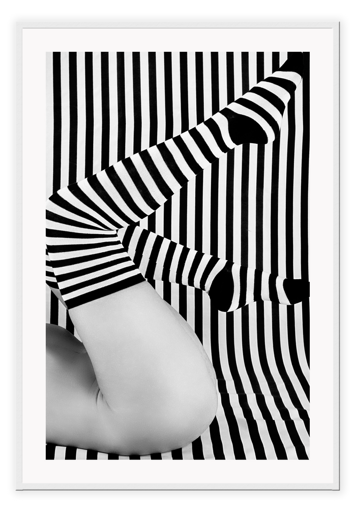 Black and white modern print featuring striped background and bottom half of a woman wearing striped socks.