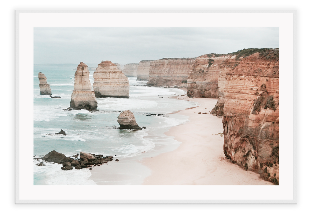 Landscape photography print showing the Twelve Apostles in Victoria, Australia with red rocks and cliffs sorrounded by sand and the ocean.