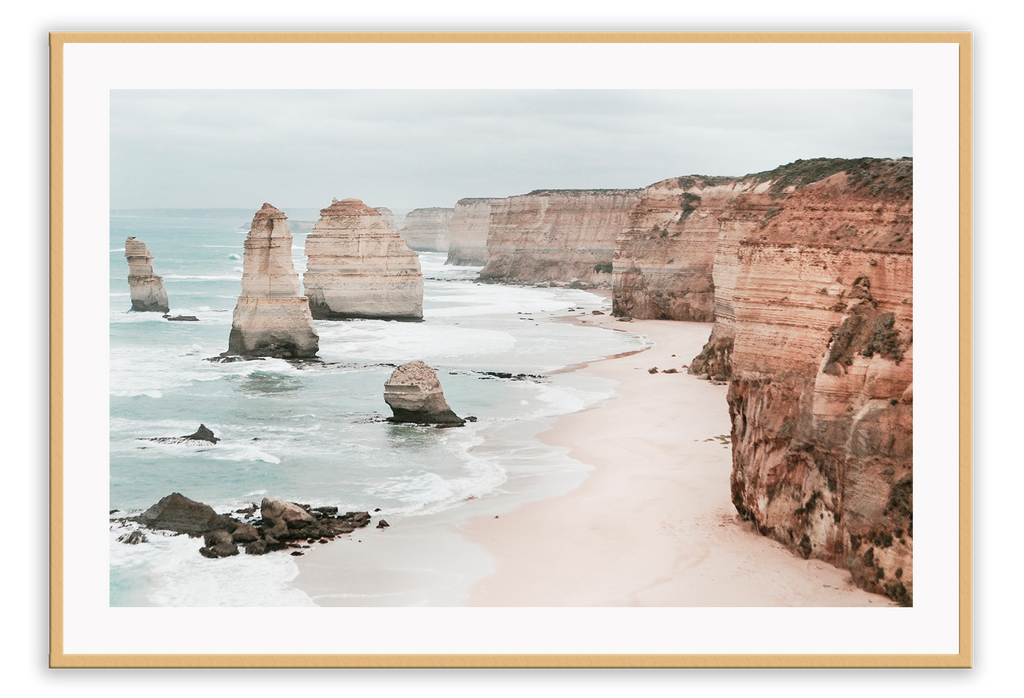 Landscape photography print showing the Twelve Apostles in Victoria, Australia with red rocks and cliffs sorrounded by sand and the ocean.