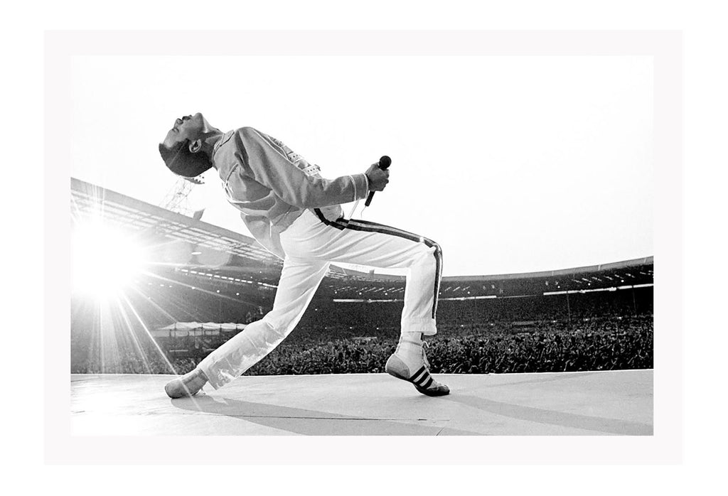 Black and white photography print of Freddie Mercury performing at live aid leaning backwards in front of the crowd.