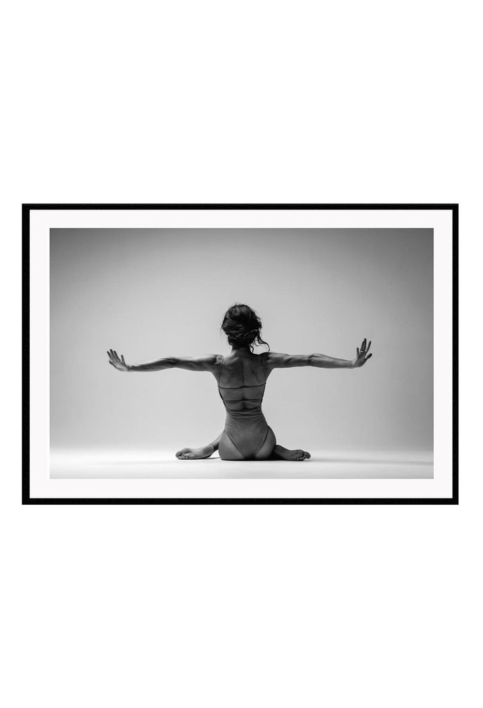 Landscape photography black and white print with woman sitting arms extended grey background 